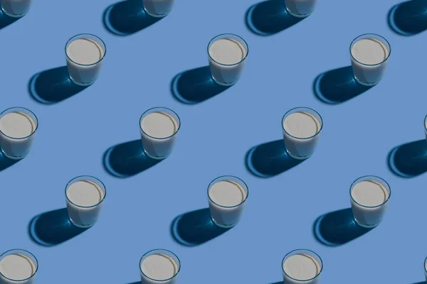 World Milk Day. Pattern on a blue background. A glass of milk. Pattern.