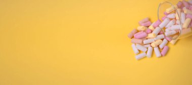 Sarı arkaplanda renkli şekerlemeler, fotokopi alanı, üst manzara. Pankart