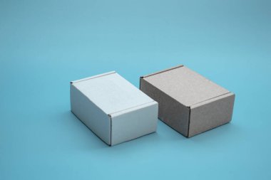 Fotokopi alanı olan karton kutuların yakın çekimi. İki Corton kutusu: mavi arka planda kahverengi ve beyaz. Paket, hediye, teslimat kavramı.