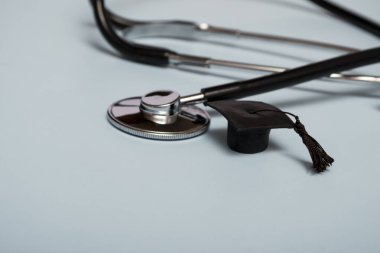 Tıp eğitimi. Steteskop ve mezuniyet şapkası. Mavi arka planda tıbbi konsept. mezun