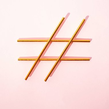 Pembe arka planda altın hashtag işareti. Sosyal medya için yaratıcı fikir.