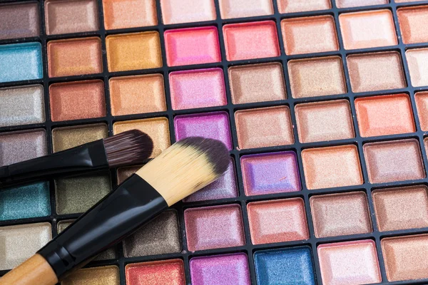 Paleta de sombras coloridas con pincel de maquillaje . — Foto de Stock