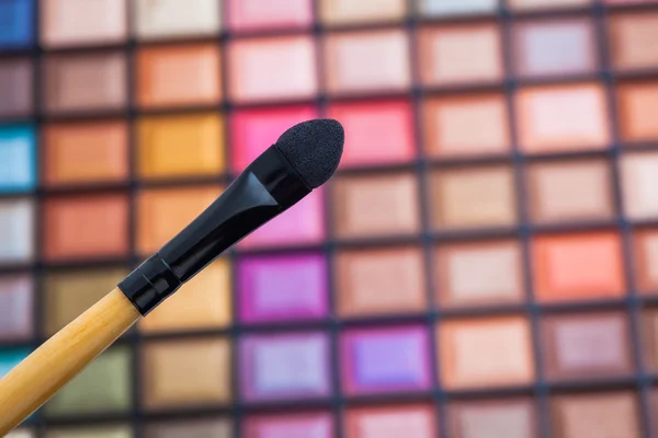 Paleta de sombras coloridas con pincel de maquillaje . — Foto de Stock