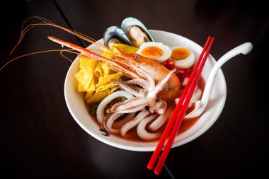 Deniz mahsulleri çorbası ve kırmızı sos ile erişte.