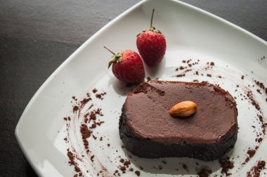 Tatlı çikolata pasta beyaz bir plaka üzerinde.