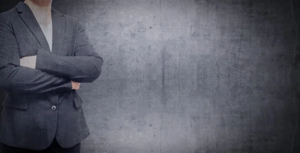 Hombre de negocios con traje cruzó los brazos sobre un fondo de pared grunge . —  Fotos de Stock