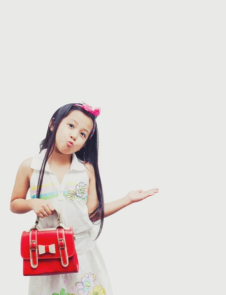 Маленька азіатська дівчинка тримає червоні сумки . — стокове фото
