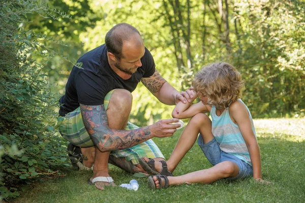Dad gives first aid Royalty Free Stock Photos