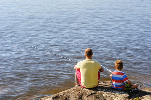 Padre e hijo sentados y pescando Imagen De Stock