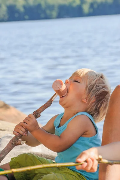 Мальчик ест колбасу Лицензионные Стоковые Фото