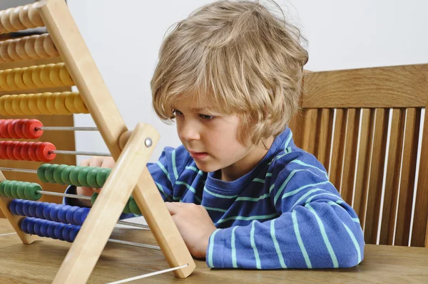 Niño aprendiendo a usar un ábaco — Foto de Stock