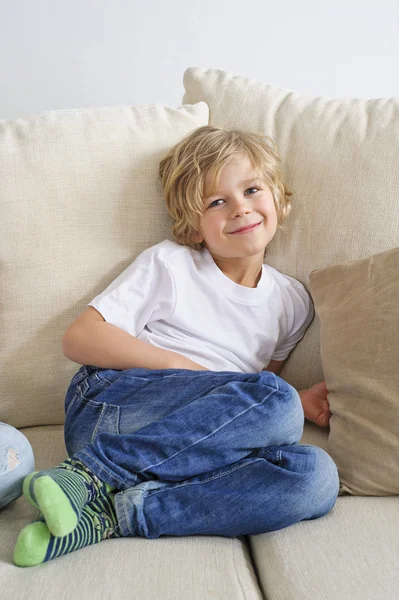 Boy sitting on sofa — Stock Photo, Image