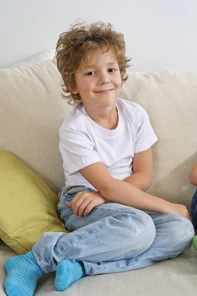 Chłopiec siedzi na kanapie — Zdjęcie stockowe