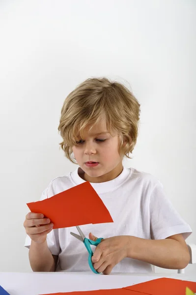 Joven chico cortando papel — Foto de Stock