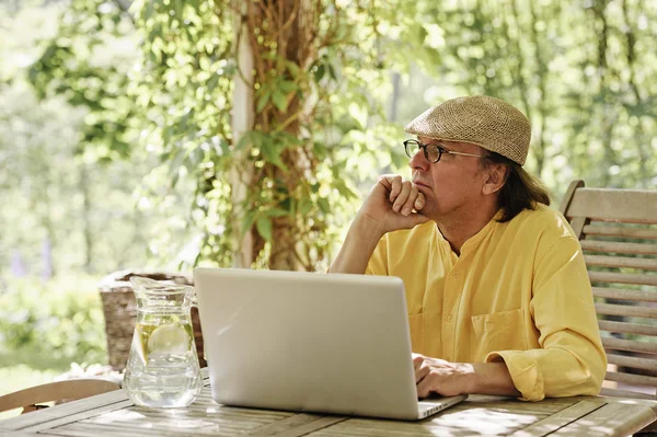 Fundersam senior mannen med laptop — Stockfoto