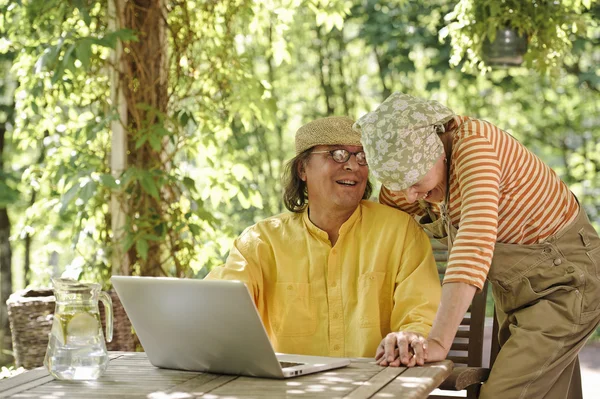 Idősebb pár, szabadban, egy laptop — Stock Fotó