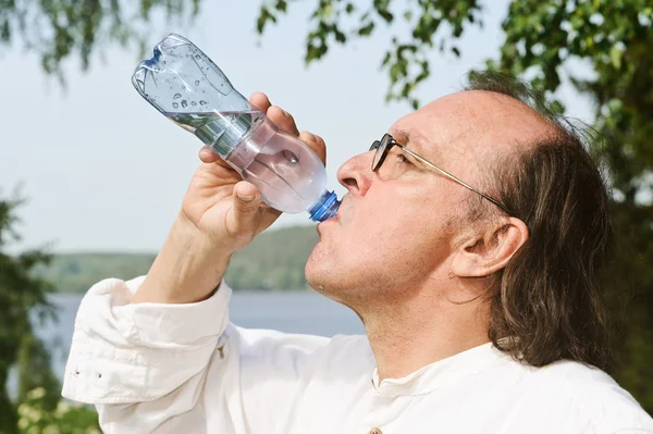 Senior trinkt Wasser aus Flasche — Stockfoto