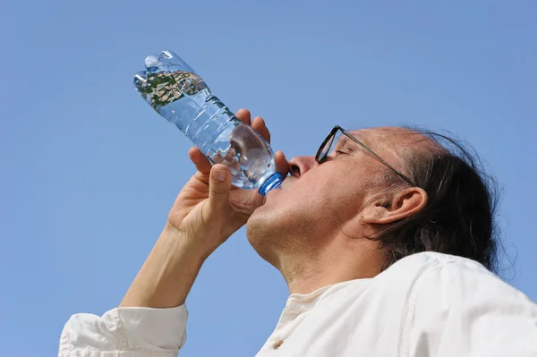 Senior trinkt Wasser aus Flasche — Stockfoto