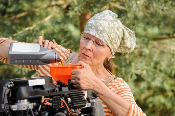 Seniorin wechselt das Öl — Stockfoto