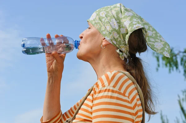 Senior woman drinks water — Stock Photo, Image