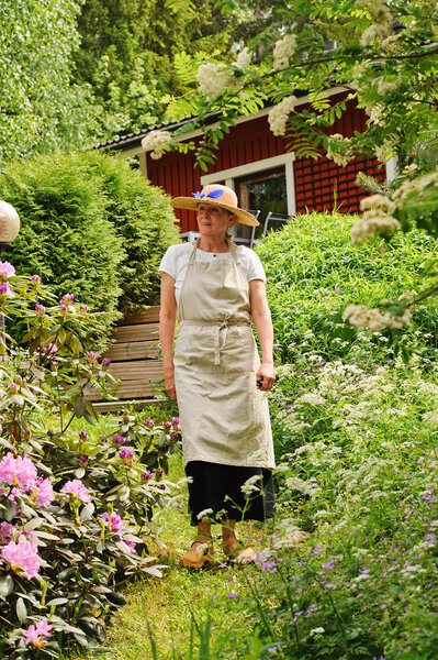 senior woman strolling in garden.