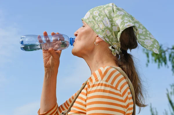 Senior woman drinks water Royalty Free Stock Images
