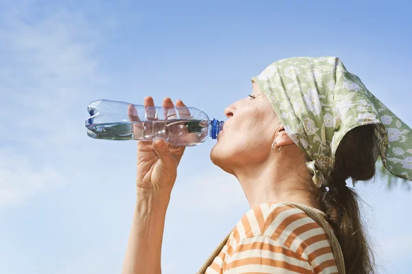 Senior womans drinks water from bottle — Stock Photo, Image