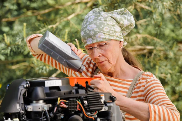 Frau wechselt Motoröl — Stockfoto