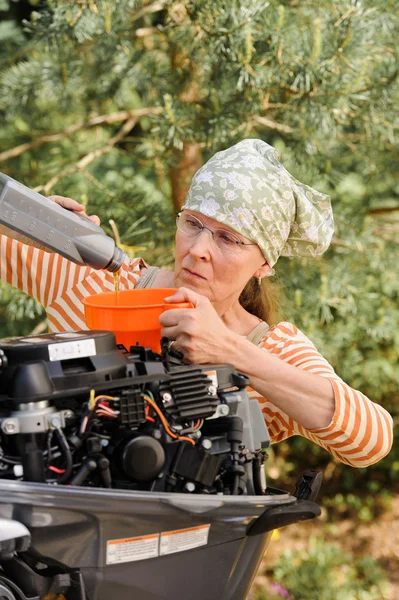 Mulher derramando óleo em motor de popa — Fotografia de Stock