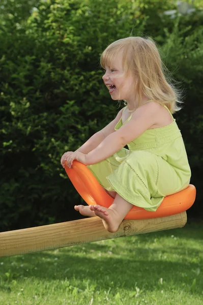 Young girl insee-saw having fun — Stock Photo, Image