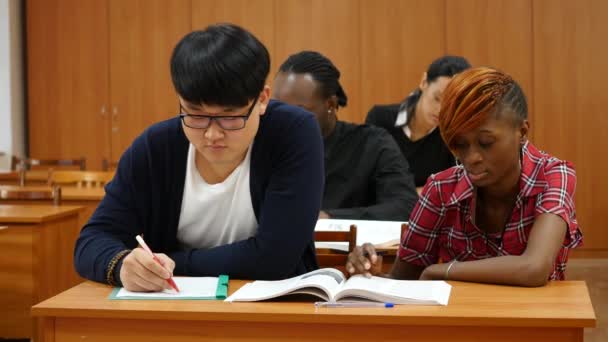 Grupp av studenter vid universitetet att göra anteckningar — Stockvideo