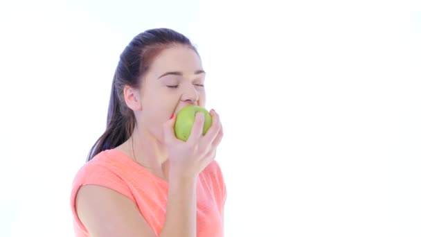 Chica muerde y mastica una manzana — Vídeo de stock