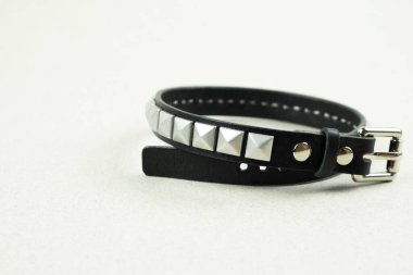 Siyah deri bilezik Freddie Mercury. Gri arka planda deliğe yakın çekim.