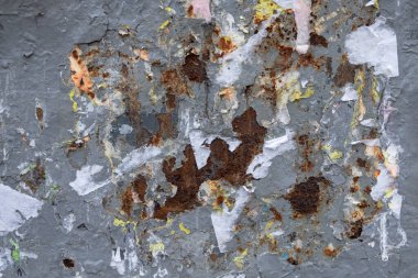 Gri kabuğu soyulmuş eski paslı metal duvar ve kağıt reklamlardan arta kalanlar. kabaca yüzey dokusu