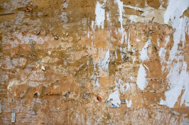Eski püskü, sarı beton duvar ve kağıt reklamları. kabaca yüzey dokusu