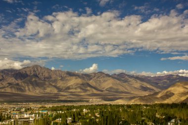 Sabah gökyüzü yeşil ormanlı bir dağ kasabasının üzerinde