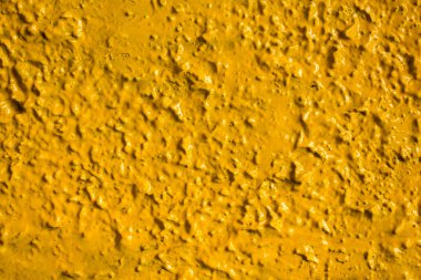 Parlak sarı duvar, parlak ışık ve gölgelerle yakın plan. kabaca yüzey dokusu