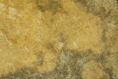 Üzerinde çizikler, hasarlar ve küf lekeleri olan eski, sarı, gri beton bir duvar. kabaca yüzey dokusu