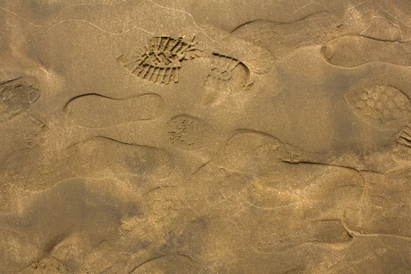 ぬれた砂の中に別の靴のプリント 表面の自然な質感 — ストック写真