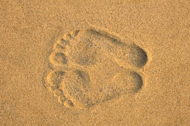 Sarı kumda iki ayak izi var. Yaklaş.