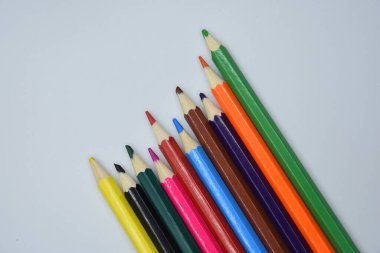 Beyaz arka plandaki lambalar ışığında birçok farklı renkli kalemlerin genel görünümü 