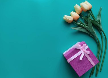 Turkuaz arka planda büyük beyaz bir plaka üzerinde turuncu parlak sarı dilimler. 