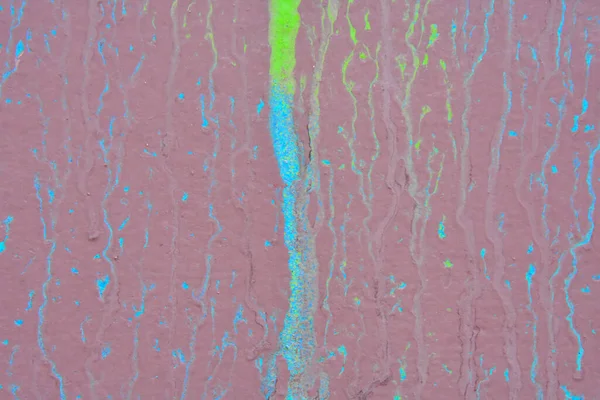 Çok sayıda düz olmayan çizgilerle kaplı canlı mor bir inşaat duvarı. 