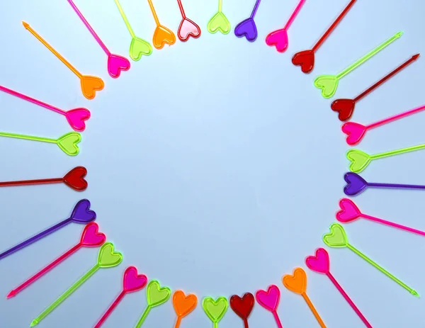 Yukarıdan, beyaz arka planda kalbi olan birçok küçük renkli kokkuyruk karışıklığı geliyor. 