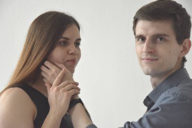 Siyah elbiseli güzel, genç ve zayıf bir kadın. Beyaz arka planda kocasının eli var.