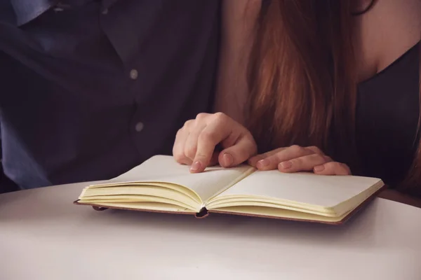 Yakışıklı koca ve güzel eş kitap okurken gündüzleri parlak, rahat bir dairede kanepede dinleniyorlar. 