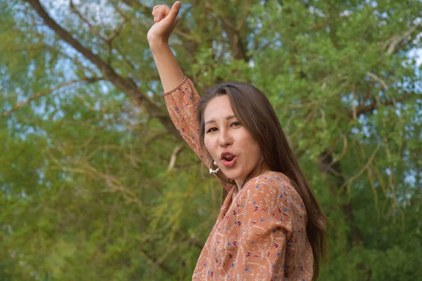 Güzel Asyalı bir kadının dudaklarını kapadığı ve gülerken yüzünü çevirdiği yerden. 