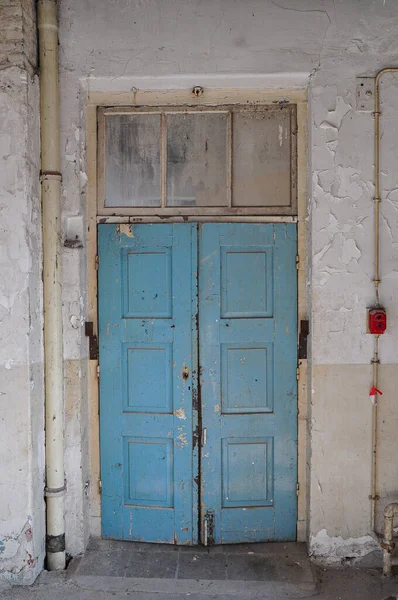 Terk edilmiş fabrikanın mavi ahşap kapısı.