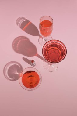 Parti kokteyl bardakları ve pastel arka planda kırmızı rujdan yapılmış romantik pembe bir düzenleme. Moda Sevgililer Günü konsepti.