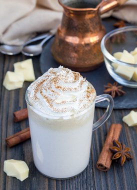 Sıcak beyaz çikolata, krema ve tarçın ile dekore edilmiş.